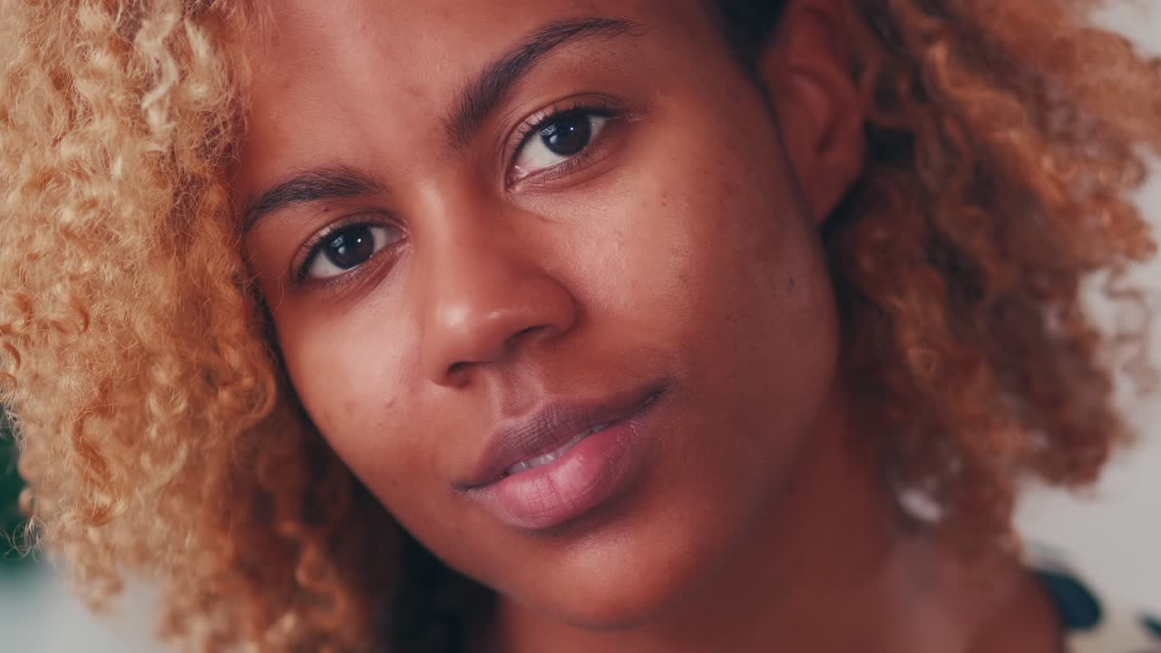 Extreme close up smiling attractive afro american woman face looking at camera