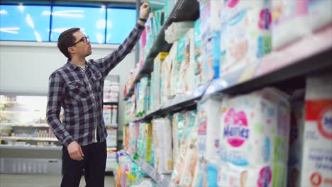 hombre comprando pañales en una tienda de comestibles