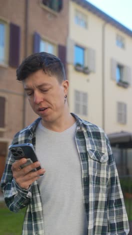 hombre mirando un teléfono inteligente en una ciudad italiana