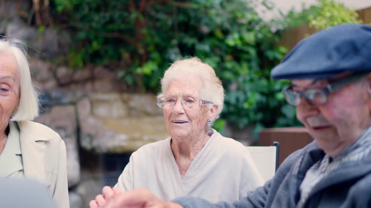 Elderly people using a laptop outdoors