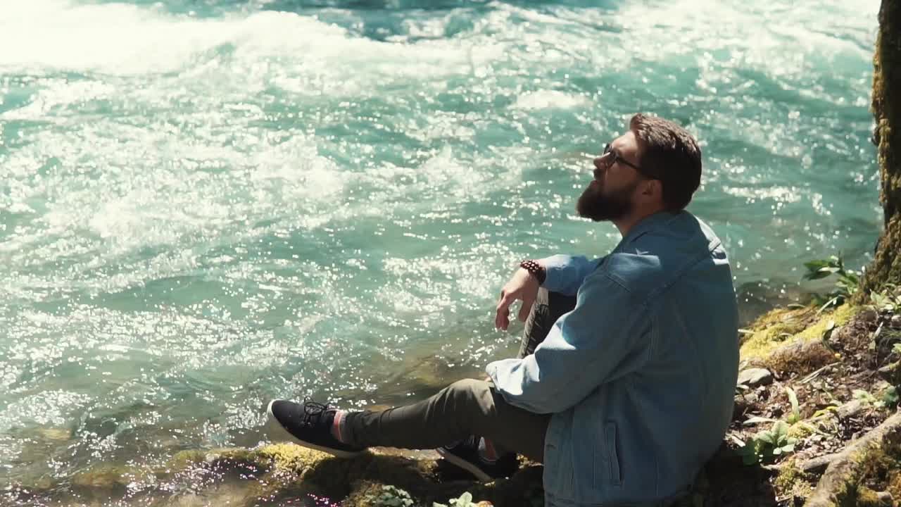 hombre relajándose junto a un río