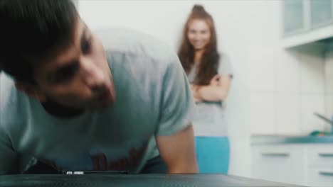 pareja en la cocina interactuando con el teléfono