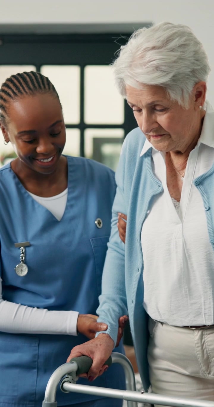 Caregiver Assisting Senior Woman Using a Walker