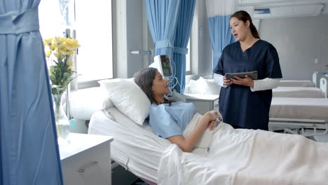 Paciente-Femenina-Diversa-En-Cama-De-Hospital-Y-Médico-Con-Tableta-Hablando,-Espacio-De-Copia,-Cámara-Lenta