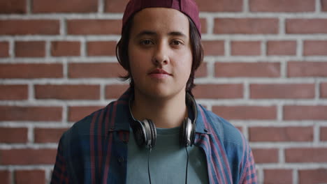 portrait successful young college student man turns head pensive teenager looking confident at camera on brick wall background slow motion