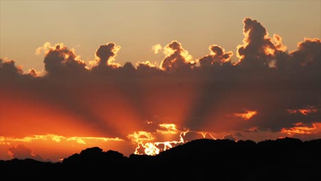 el sol se pone bajo las nubes con enormes rayos de luz