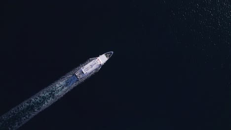 Ferry-boat-passing-Svjetionik-Jadrija-on-Dalmatia-coast-in-Croatia,-top-down