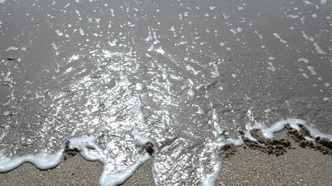 Inscription of the name of month on sand, the beach. Shooting on the beach