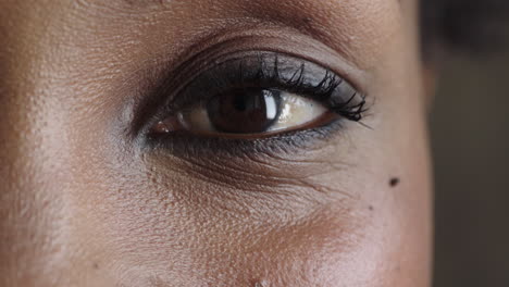 cerca del ojo de la mujer negra mirando a la cámara parpadeando pensativo contemplativo hermoso detalle