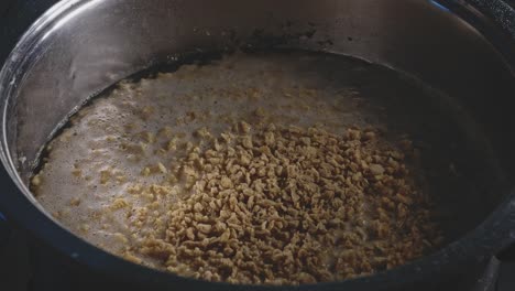agregar proteína vegetal de textura a una sartén llena de agua hirviendo, vista de cerca