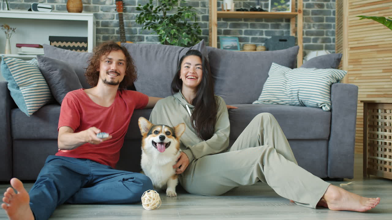 Couple and Dog Relaxing on the Floor Watching TV