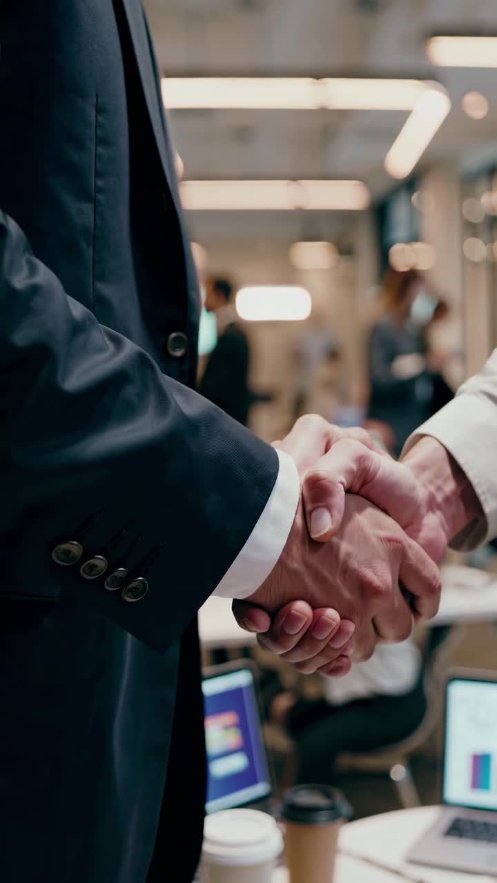 Primo piano, foto all'altezza degli occhi di una stretta di mano in un ufficio moderno, che cattura un accordo professionale