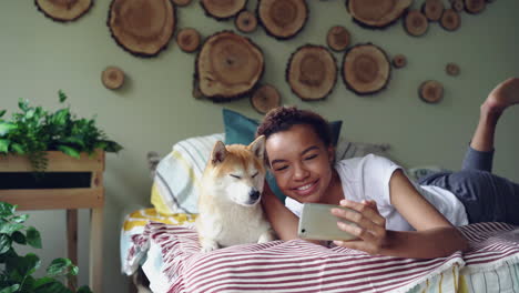 teenager taking a selfie with her dog on the bed
