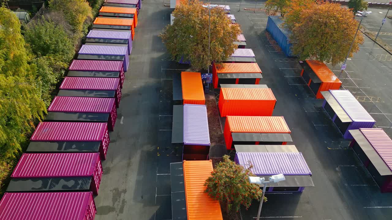Aerial footage of multicolored porta cabins, market stalls, steel cabins, storage units, shot from above and moving slowly forwards
