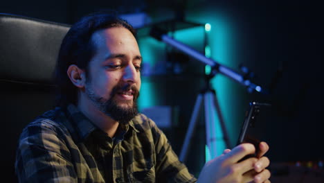 Smiling-man-at-home-texting-best-friend-on-smartphone,-taking-break-from-work