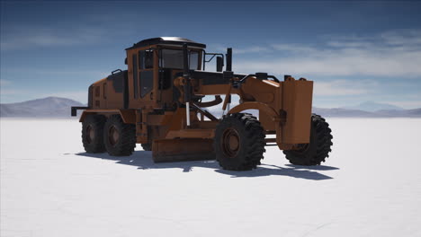 road grading machine on the salt desert road