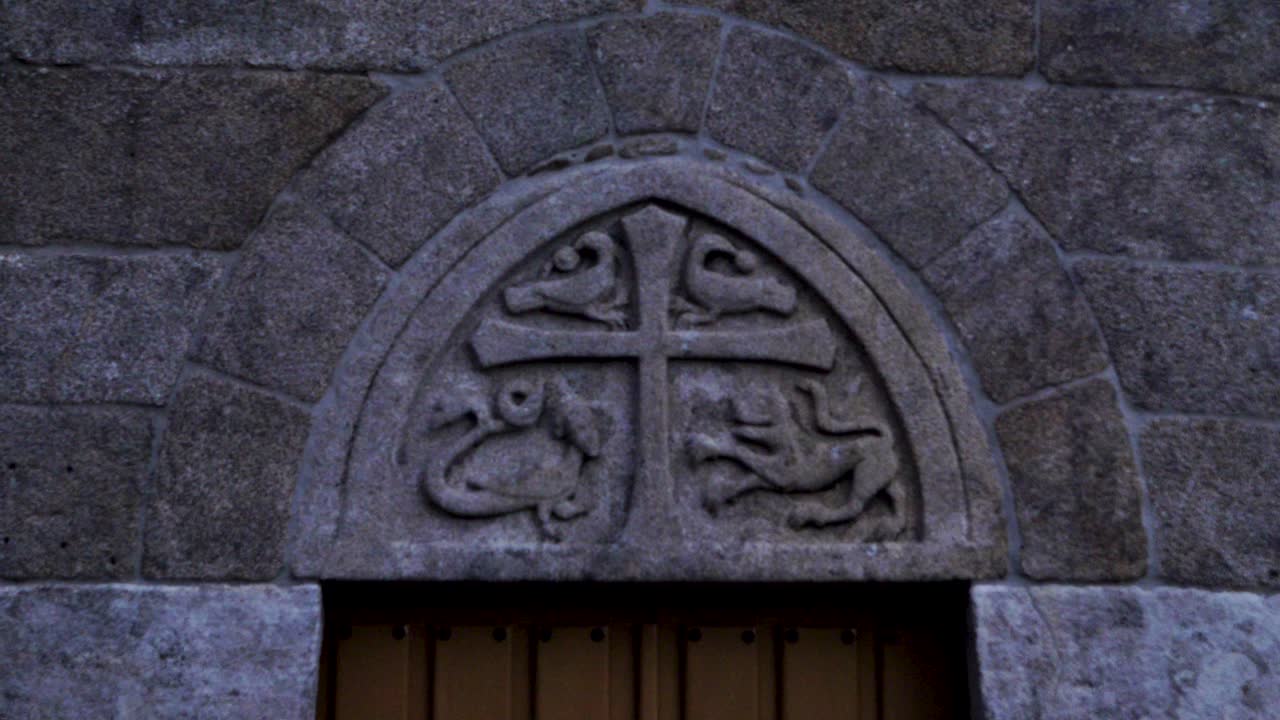 detalle de piedra tallada de cruz y serpiente león y animales de pescado en la antigua iglesia