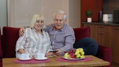 Pareja-De-Abuelos-Mayores-Hablando-Y-Usando-Una-Tableta-Digital-En-Casa.-Cierre-De-Emergencia-Por-Coronavirus