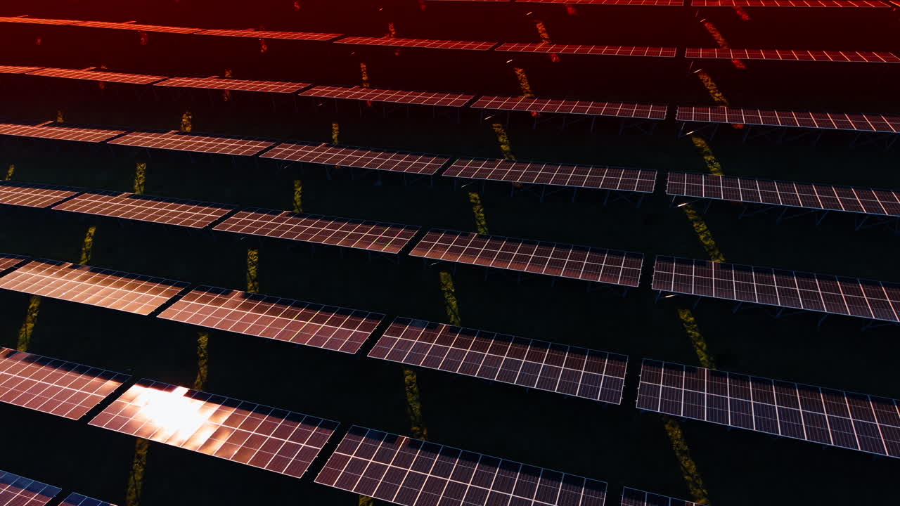 La luce dorata del tramonto illumina il vasto impianto solare. Tecnologia ecologica per il risparmio energetico. Vista aerea