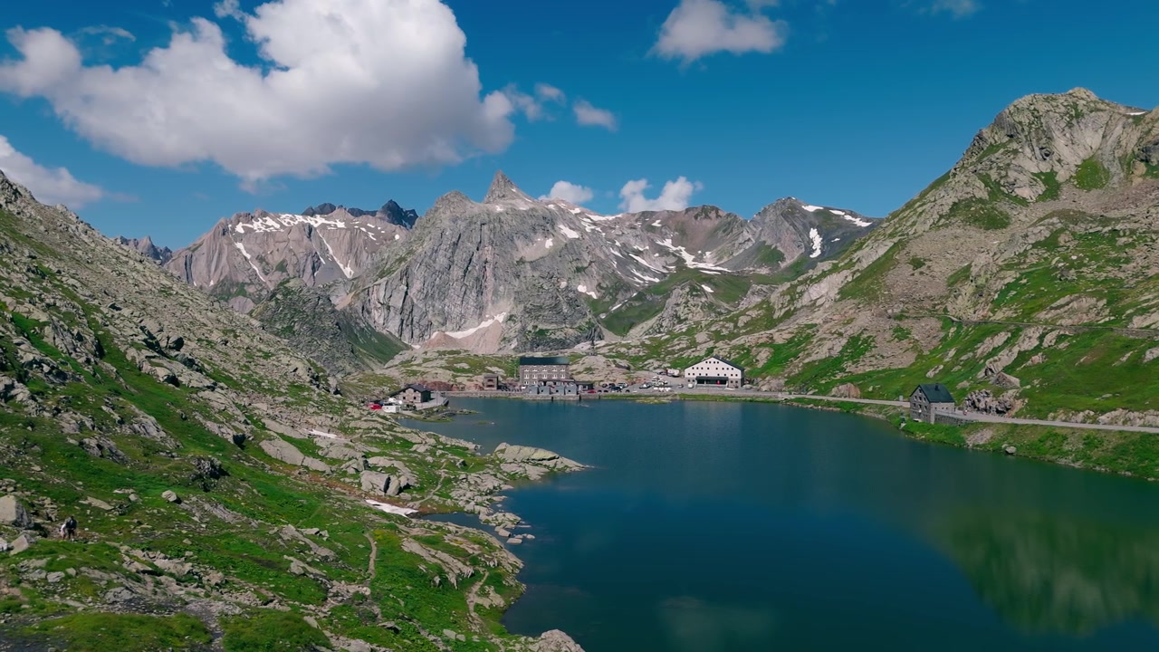 Yaz aylarında Büyük St. Bernard Geçidi'ndeki alp gölü ve engebeli dağların havadan görünümü.