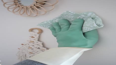 cleaning a light beige wall with decorative accessories