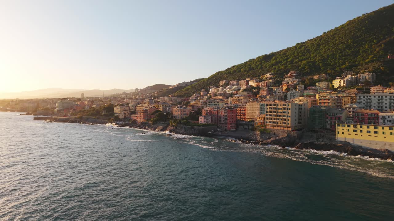 Sunset light over coastal town with colorful buildings, view from a drone