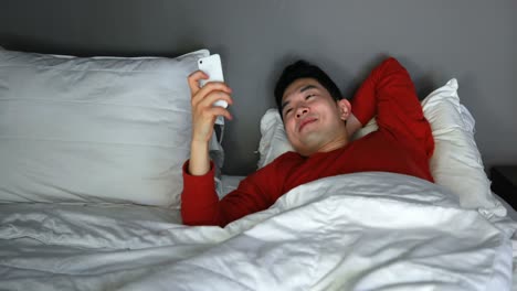 man using mobile phone on bed 4k