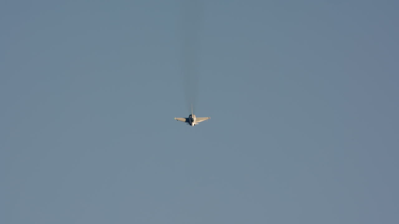 Kraftfuldt jagerfly flyver og manøvrerer på klar blå himmel