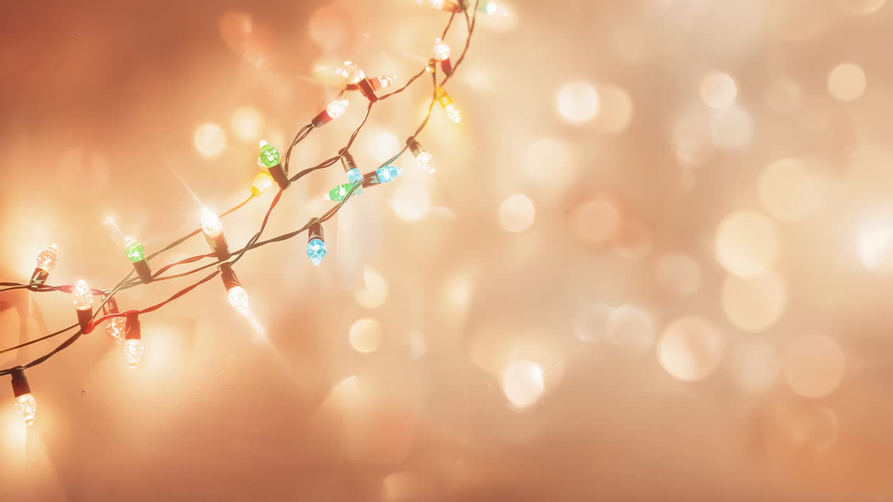 Flickering diagonal strand of colored bulbs on wire swaying at mantel, frames causing alternation