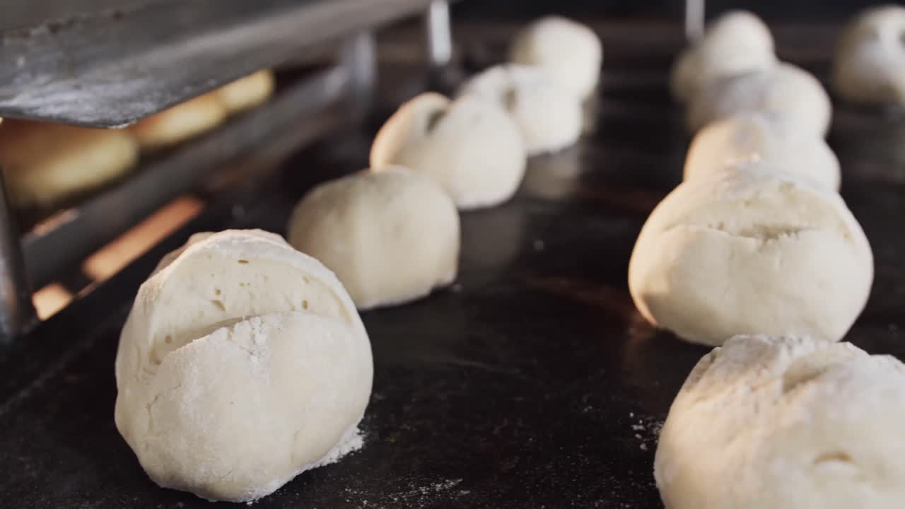 close up de rollos crudos y horneados en los estantes de la cocina de la panadería, cámara lenta