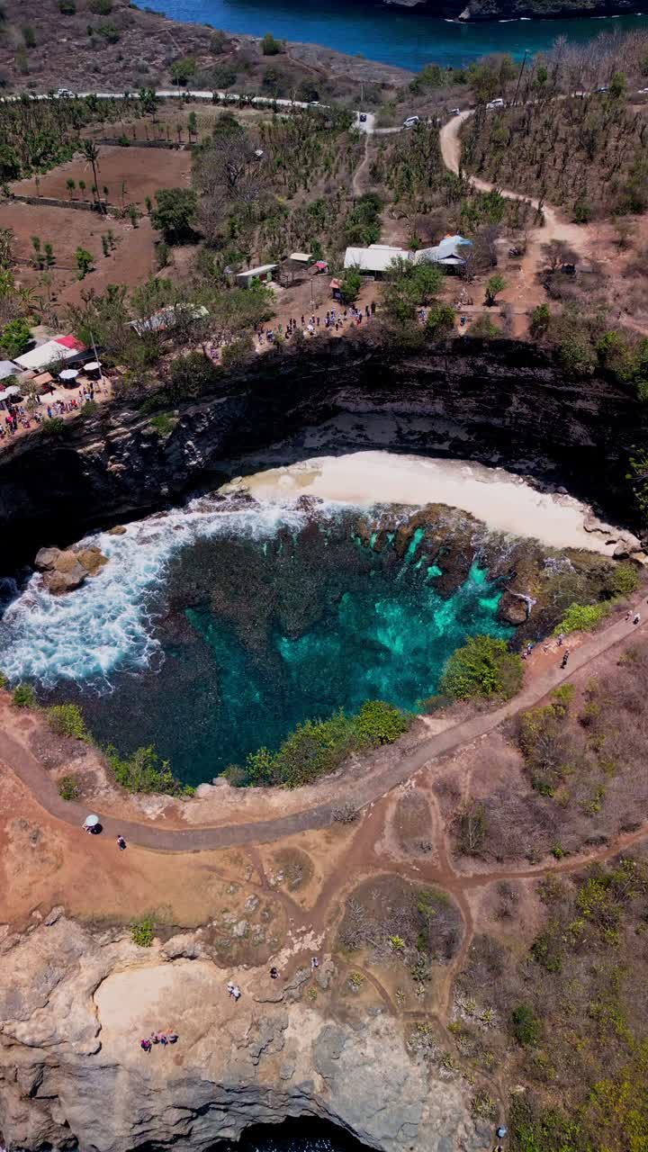 Vertical drone footage over Broken Beach reveals the impressive natural stone bridge and surrounding turquoise waters that highlight Nusa Penidas dramatic coastline.