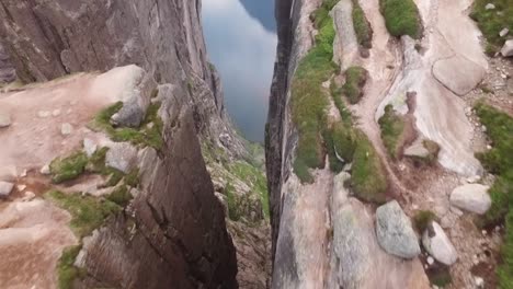 una vista aérea muestra a una pareja de pie en kjeragbolten una roca en la montaña kjerag en rogaland noruega