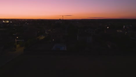 aerial of residential town skyline at dusk with beautiful pink sky