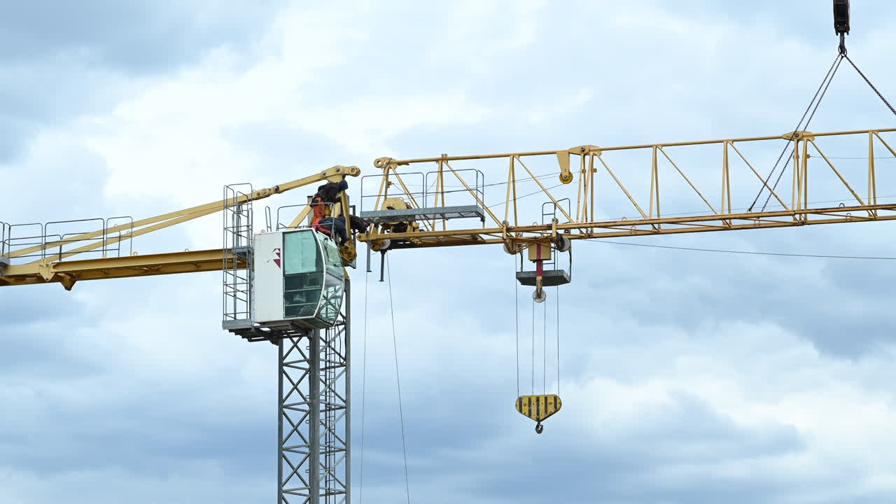 Engineers working on yellow tower crane during construction setup