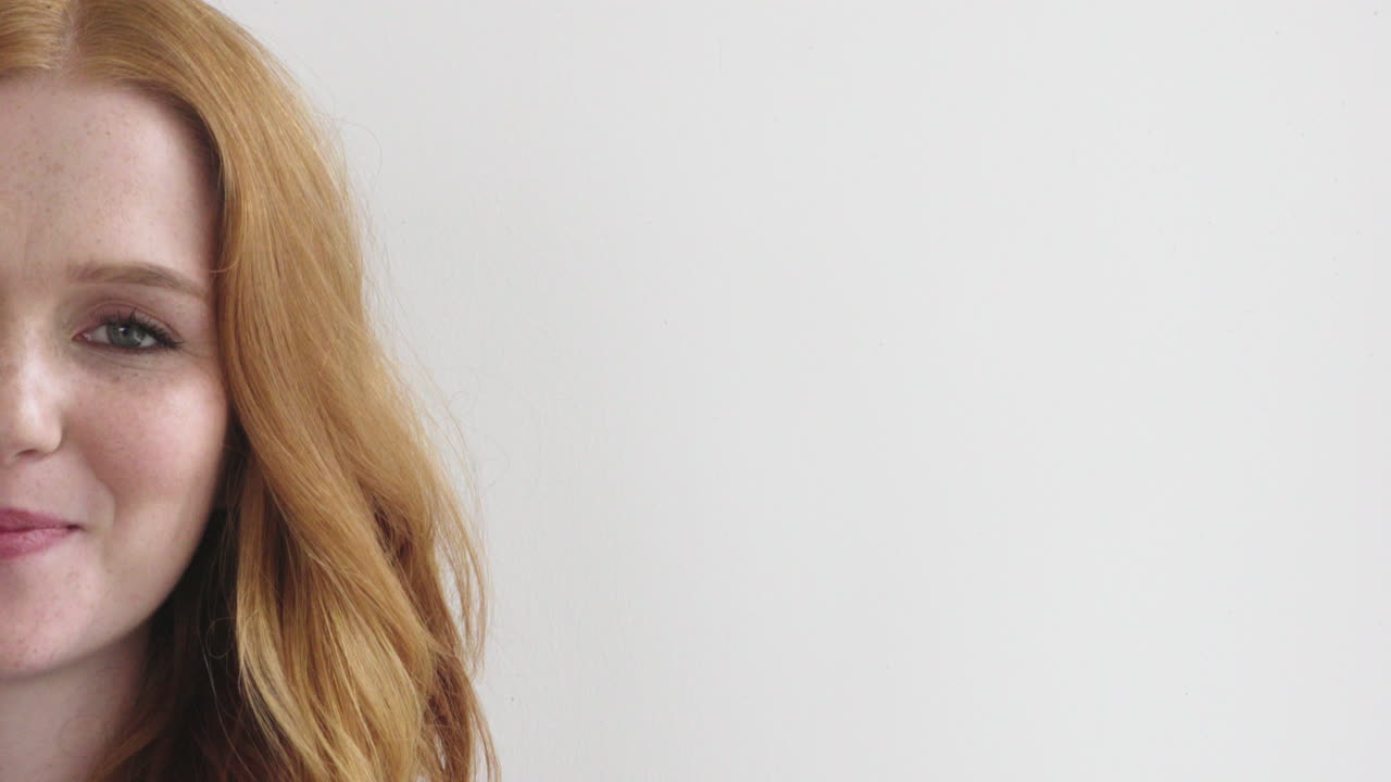 retrato de una hermosa mujer joven de cabello rojo sonriendo feliz aislada en un fondo blanco copia el espacio de la mitad de la cara