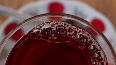 primer plano de té turco en una taza de vidrio con burbujas