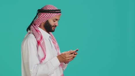 Islamic-guy-playing-online-game-on-phone