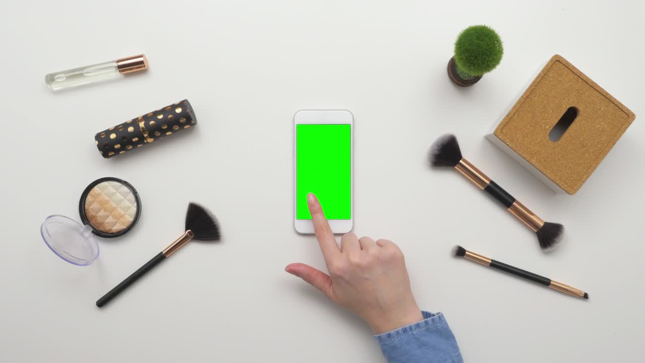 아름다움 제품에 의해 스마트폰을 사용하는 여성의 상단 뷰 오버헤드 영상
