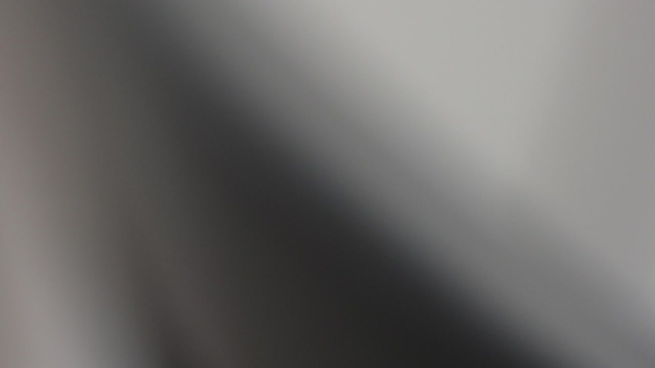 Static close up racks to freshly painted grey wooden chair back in paint booth