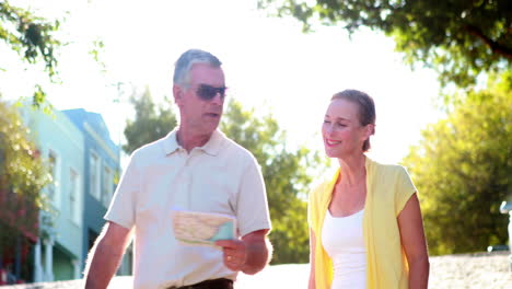 Happy-tourist-couple-reading-map-and-walking