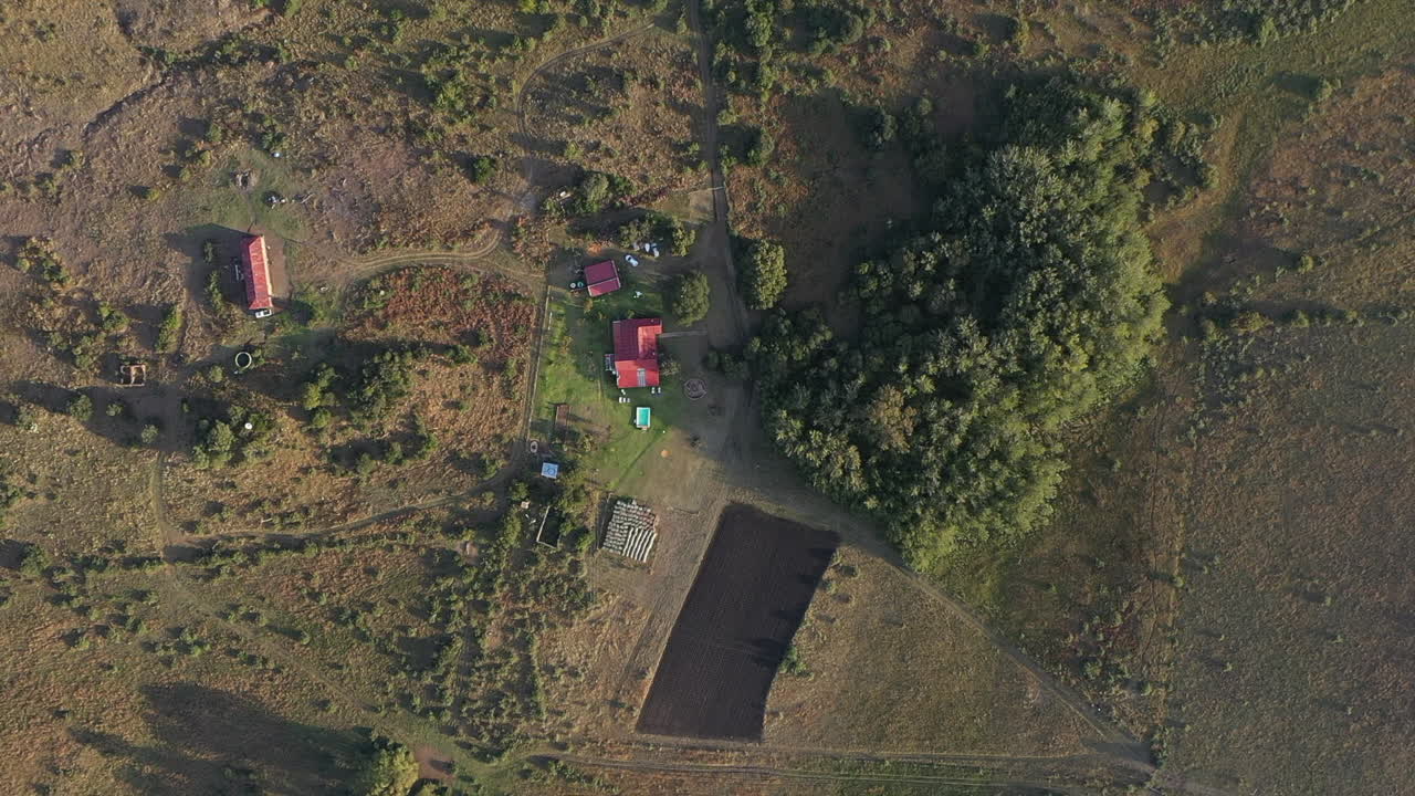 Luftfoto af et sydafrikansk farm-landskab med et rødtaget hus og træer