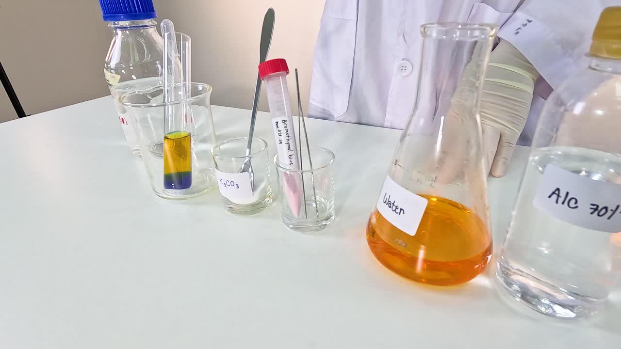 A scientist conducts a bromothymol blue experiment, observing color changes in a lab setting with controlled lighting