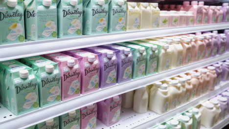 rows of colorful bottled and cartoned products on shelves in a supermarket