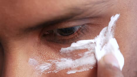 man applying beauty cream onto skin