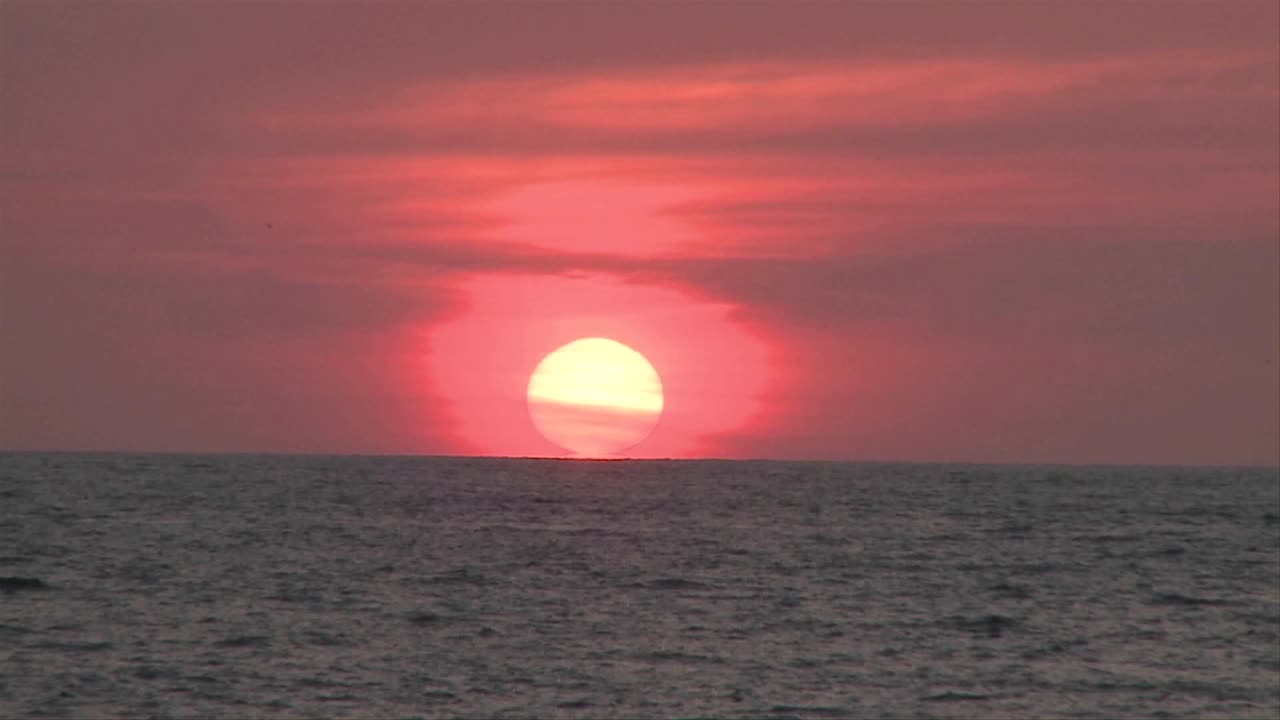 el sol se pone a lo lejos en puerto vallarta méxico en un resort de playa