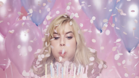 Beautiful-young-woman-blowing-out-candles-celebrating-birthday-pink-and-blue-balloon-background---Red-Epic-Dragon