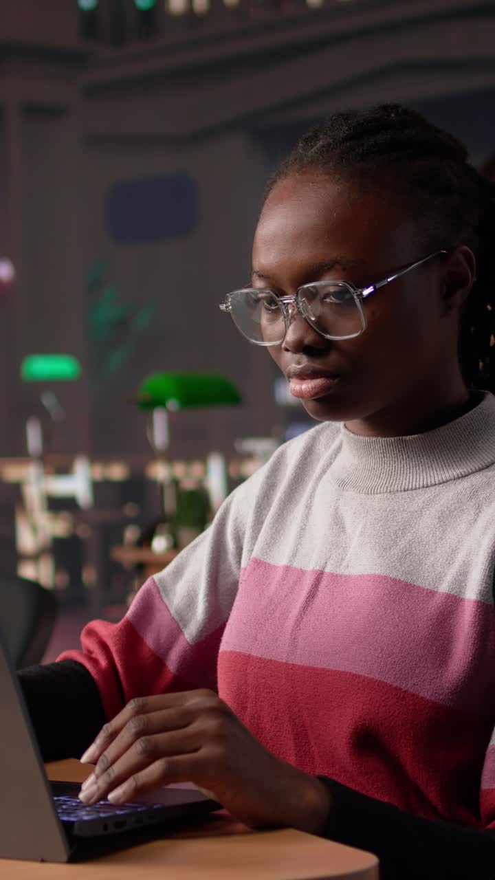 Vertical video young black learner focusing on literature assignment by gathering data