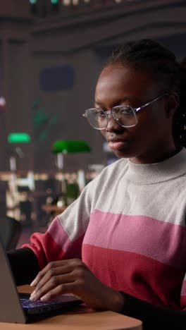 vertical video young black learner focusing on literature assignment by gathering data
