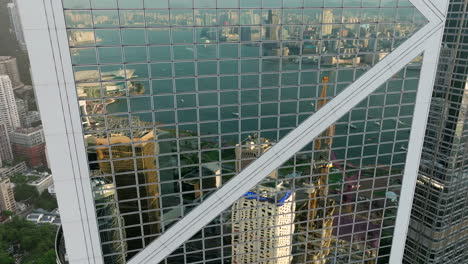 reflection of hong kong skyline and victoria harbour in bank of china windows, arial view of city