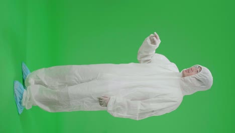 side view of full body angry asian man wearing personal protective equipment uniform ppe and pointing displeased and frustrated to the camera in the green screen studio